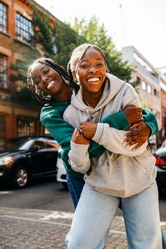 two women hugging each other on the street