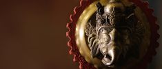 an elephant head is mounted on a red and gold wall hanging in front of a mirror