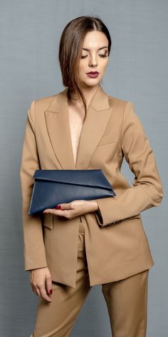 Beautiful and unique leather clutch with detachable short gold high quality chain. The bag is simple, it has modern shape. It can be carried by hand, on the shoulders. Also it is suitable for many outfits. All our bags are handcrafted in small workshop in Poland, where work peaple with big experience. It has embossed logo at the bottom of the bag. It has one pocket, closed with zipper. Interior is lined with high quality fabric. The flap is fastened with magnetic. READY TO SHIP: 2 DAYS Metallic Dark Blue Bag Outfit, Versatile Leather Clutch For Work, Soft Leather Rectangular Clutch For Party, Minimalist Structured Shoulder Bag For Evening, Minimalist Structured Evening Shoulder Bag, Modern Blue Clutch For Formal Occasions, Luxury Soft Leather Party Clutch, Modern Leather Clutch Evening Bag, Versatile Rectangular Clutch For Formal Occasions