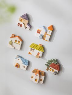 small wooden houses are arranged on a white surface