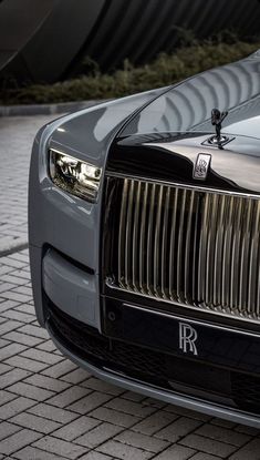 the front end of a black and silver rolls royce