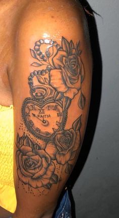 a woman's arm with roses and a heart tattoo on the side of her shoulder