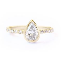 a yellow gold ring with a pear shaped diamond