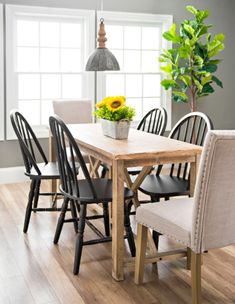 a dining room table with six chairs and a potted plant on the top of it