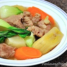 a white bowl filled with meat and vegetables