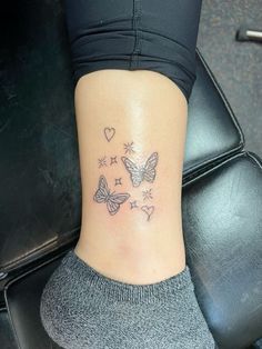 a woman's ankle with butterflies and hearts on it