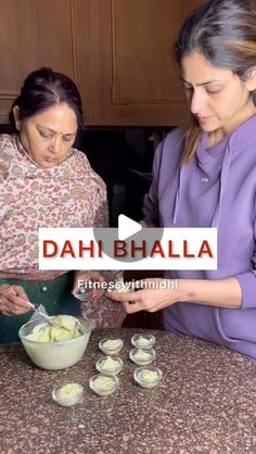 two women preparing food on top of a kitchen counter with the words dahi bhalla