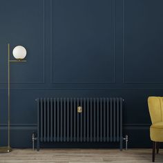 an empty room with a radiator, chair and lamp on the floor next to it