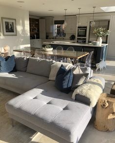 a living room filled with furniture next to a kitchen