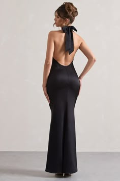 the back of a woman wearing a black dress with a bow on it's neck