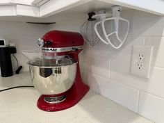 a red mixer sitting on top of a kitchen counter