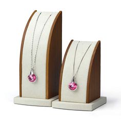 two necklaces with pink stones on display stands