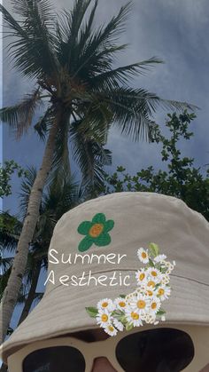 a woman wearing sunglasses and a hat with the words summer aesthetic written on it in front of palm trees