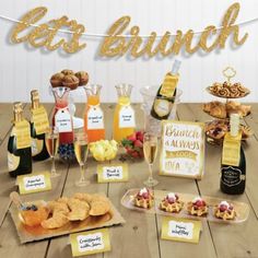 a wooden table topped with lots of desserts and bottles of wine on top of it