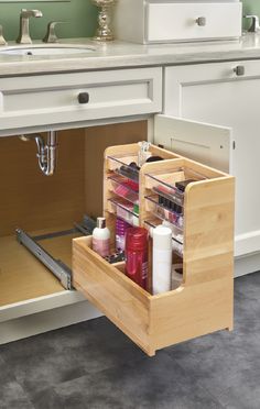 an open drawer in a kitchen next to a sink