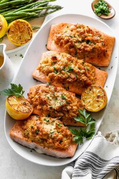 salmon fillets on a plate with lemons and asparagus