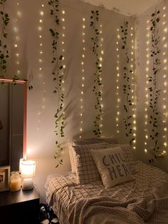 a bedroom decorated with lights and greenery on the wall, along with a bed