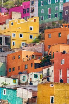 many colorful buildings with windows and balconies on the top of each building, all in different colors