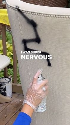 a person spray painting the side of a large white chair with words on it that say i was super nervous