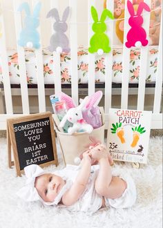 a baby laying on the floor next to some bunny decorations