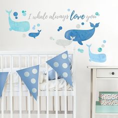 a baby's room decorated with blue whale decals and polka dot bunting