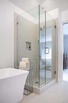 a bathroom with a glass shower door and white bathtub