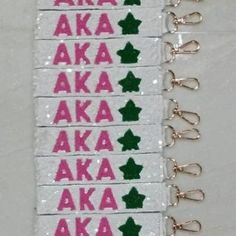 some type of key chain with pink and green letters on it