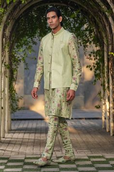 Mint green sleeveless Nehru jacket with stitchline thread embroidery in stripe pattern. Paired with floral print pleated kurta and churidar. - Aza Fashions Green Fitted Kurta With Stand Collar, Fitted Green Cotton Bandhgala, Fitted Green Bandhgala For Spring, Spring Green Fitted Bandhgala, Traditional Green Nehru Jacket For Spring, Traditional Sleeveless Green Nehru Jacket, Sleeveless Green Traditional Nehru Jacket, Festive Green Nehru Jacket With Stand Collar, Fitted Green Nehru Jacket For Spring