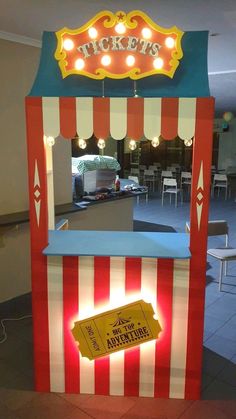 a carnival ticket booth with lights on the front and back sides, in an indoor area