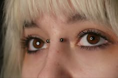 a close up of a woman's eyes with piercings