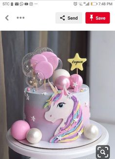 a birthday cake decorated with pink, white and blue icing has a unicorn on it