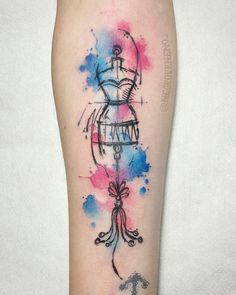 a woman's leg with watercolor tattoos on it and an abstract design in the middle