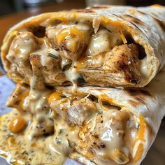 chicken and cheese burritos are stacked on top of each other with melted cheese