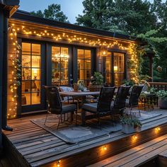 an outdoor dining area with lights on the deck