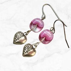 These exquisite small silver heart charm and pink glass dangle earrings are sure to capture hearts.  Puffy silver hearts beautifully complement pink Czech glass beads, adding a charming and vibrant pop of color to any outfit.  The pink and white Czech glass beads are made of clear glass infused with pink glass; each bead is different and special. Just beautiful.  Hypoallergenic ear wires (nickel and lead free). Choose ear wires at checkout. A gift for you or someone special, earrings are carded Sterling Silver Jewelry With Pink Heart Beads, Elegant Pink Heart Metal Earrings, Heart Beads Metal Earrings For Gift, Metal Heart Beads Earrings For Gifts, Metal Heart Beaded Earrings For Gifts, Nickel Free Pink Heart Pendant Jewelry, Pink Metal Heart Earrings For Pierced Ears, Pink Nickel-free Beaded Drop Earrings, Gift Metal Heart Earrings With Heart Beads