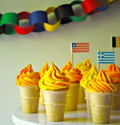 cupcakes with yellow frosting and flags on them