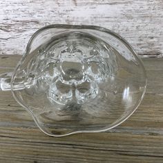 an empty glass teapot sitting on top of a wooden table