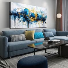 a living room filled with blue couches and a large painting hanging on the wall