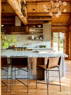 a kitchen with an island and chairs in it