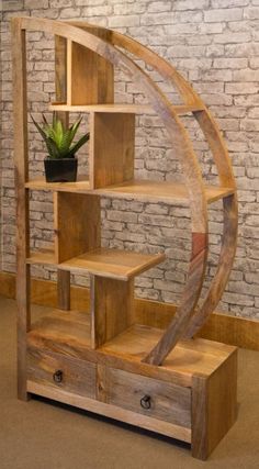 a wooden book shelf with drawers and shelves on the bottom, in front of a brick wall