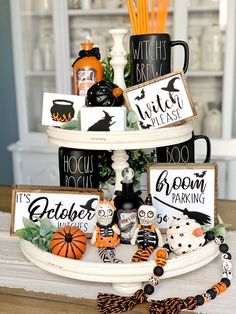 a three tiered tray with halloween decorations on it and the words witches, boozies, etc