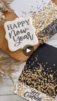 a cookie with the words happy new year written on it next to some gold confetti