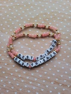 Best Friends bracelets are always cute and this set is the perfect gift for you and your bestie. This duo of handmade beaded bracelets feature metallic gold spacer beads with coral pink seed beads 4mm clear faceted beads with 5mm white and black square alphabet letter beads. Bracelets are approximately 7 inches and is made with clear stretchy elastic and should small and medium wrists. If you need a smaller or larger size, message me and I'll see what I can do! Please be careful with the bracelet as it is not indestructible. Avoid water, gels, lotions, soaps, etc. Not intended for children. Please note that beads are a choking hazard and I am not liable if they are ingested. Cancellations are accepted within 24 hours. Pink Faceted Beaded Bracelets For Everyday, Everyday Pink Beaded Bracelets With Faceted Beads, Rose Gold Beaded Bracelets Colorful Beads Gift, Rose Gold Beaded Friendship Bracelets With Round Beads, Pink Friendship Bracelets With Spacer Beads, Handmade Pink Beaded Bracelets For Best Friend Gift, Trendy Letter Beads For Friendship, Dainty Friendship Beaded Bracelets With Letter Beads, Personalized Round Bead Friendship Bracelets For Best Friend