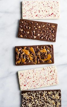 three different types of candy bars on a white counter top with sprinkles