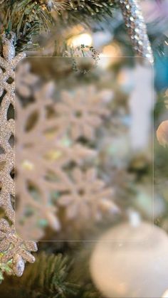 an ornament hanging from the top of a christmas tree with snowflakes on it