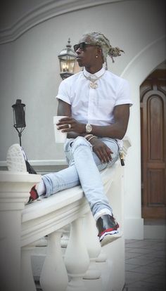 a man sitting on top of a white bench