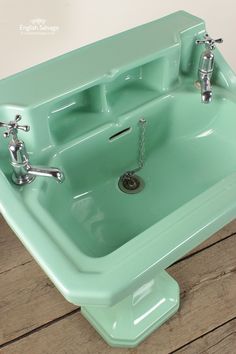 a green sink with two faucets on it