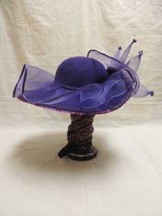 Vintage Purple Red Hat Society in Wool and Tulle with Sequins. This is a vintage Red wool hat society hat and is one size fits all. A beautiful purple floppy hat with brim turned up in the front, decorated with purple tulle, a purple sequined applique and tiny sequined at the end of each bough of tulle. The Red Hat Society is an international social organization that was founded in 1998 in the United States for women age 50 and beyond, but now open to women of all ages. Its main purpose is to pr Luxury Purple Mini Hat With Curved Brim, Cheap Adjustable Purple Hats, Purple Wide Brim Mini Hat For Summer, Vintage Purple Hat With Short Brim, Vintage Short Brim Purple Hat, Purple Brimmed Summer Fascinator, Purple Mini Hat With Curved Brim For Beach, Purple Wide Brim Adjustable Costume Hat, Lavender Wide Brim Hat For Kentucky Derby