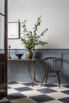 a chair and table with a potted plant on it in front of a mirror