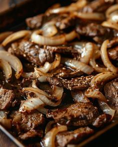 the meat and onions are being cooked on the grill